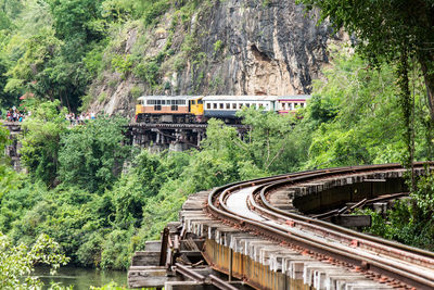 Train on railroad tracks against cliff