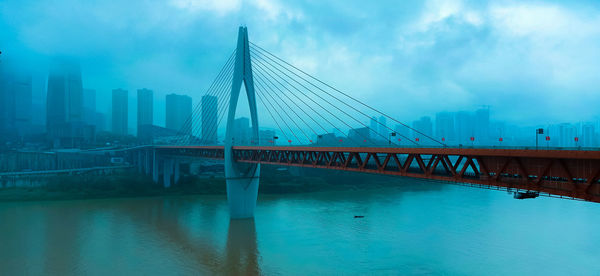 View of bridge over river against cloudy sky