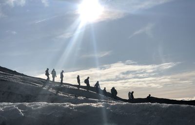 Silhouette people against sky