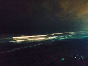 Aerial view of illuminated sea against sky at night