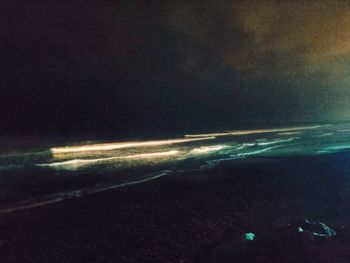 Aerial view of illuminated sea against sky at night