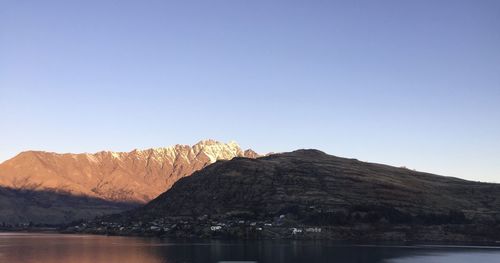 Scenic view of lake and mountains against clear sky