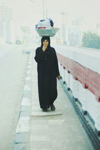 Portrait of woman standing against wall