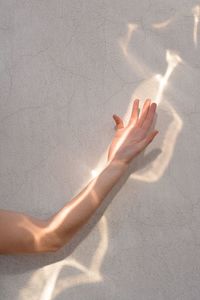 Cropped hand of woman by wall