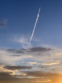 Low angle view of vapor trail against sky during sunset