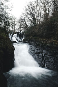 Scenic view of waterfall against sky