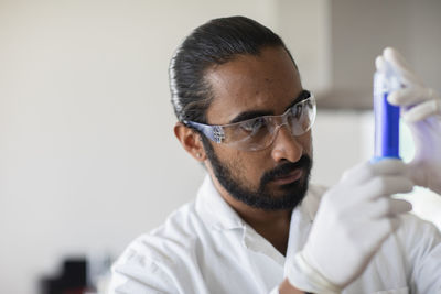 Young man scientist with lab coat checking a sample