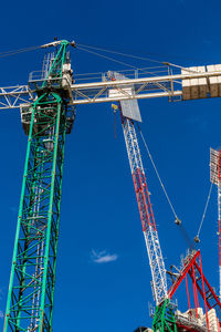 Low angle view of crane against blue sky