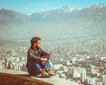 Man in a viewpoint to city with mountains at background