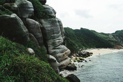 Rock formations by sea against sky