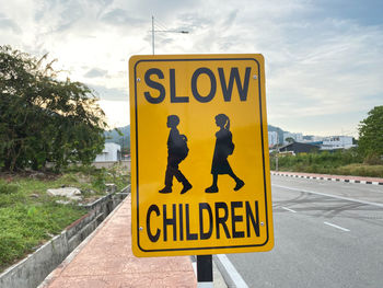 Information sign on road against sky