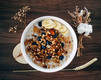 Flatlay of cereal, granola and fruits. decorated with dried plants