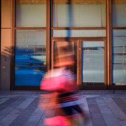 Blurred motion of woman walking in city