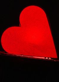 Close-up of red heart shape over black background