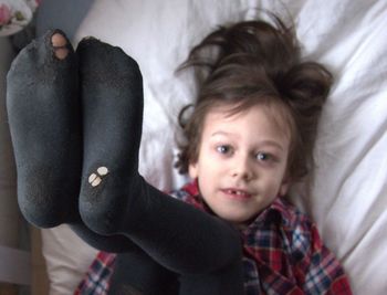 Portrait of cute girl lying on bed at home