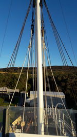 Low angle view of suspension bridge against clear blue sky