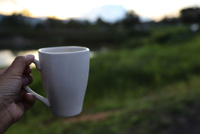 Close-up of hand holding coffee cup