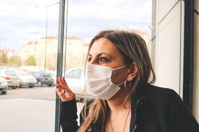 A woman with a mask looking through the window