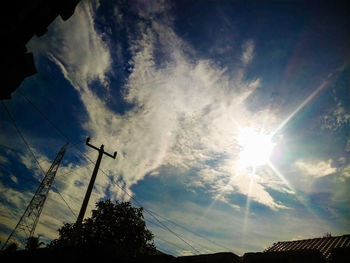 Low angle view of silhouette trees against bright sun