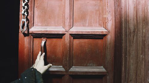 Historic wooden door and a female hand