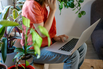 Midsection of woman using laptop at home