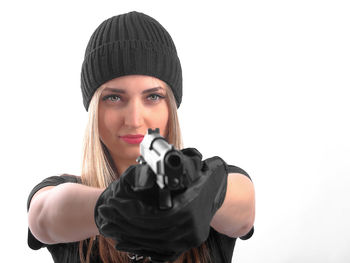 Portrait of young woman wearing hat against white background