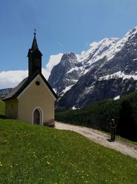 Church on field by building against sky