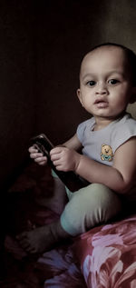 Cute baby girl sitting on bed