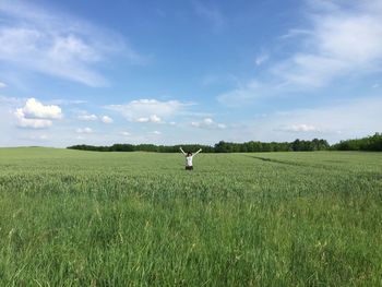 Woman standing on agricultural field against sky