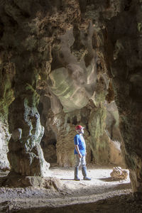 Full length of man standing on rock in cave