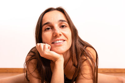 Portrait of smiling young woman sitting at home