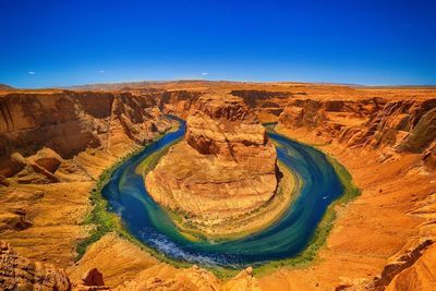 Scenic view of horseshoe bend against clear blue sky