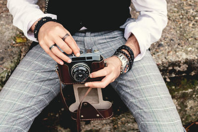 Close-up of unrecognizable man using analog photo camera.