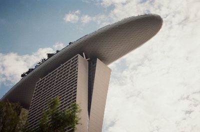 Low angle view of modern building against cloudy sky