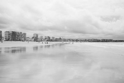 Scenic view of sea by buildings against sky