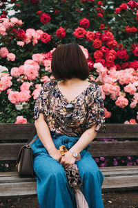 Woman sitting on pink flowering plants