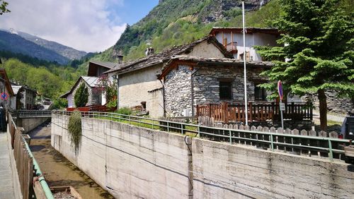 Houses by mountain against sky