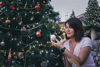 Young woman holding christmas tree