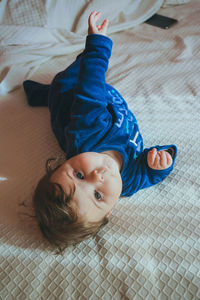 Portrait of cute baby girl on bed at home