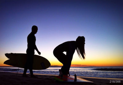 Silhouette of people on beach at sunset