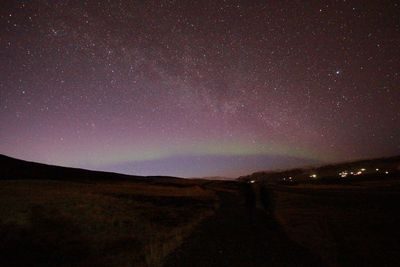 Scenic view of illuminated road against sky at night