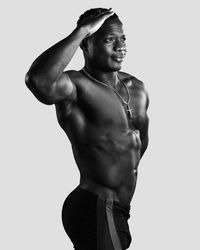 Full length of shirtless man standing against white background