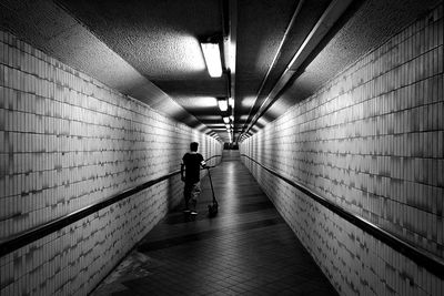 Rear view of man walking in subway tunnel