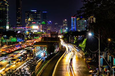 High angle view of light trails on city street amidst buildings