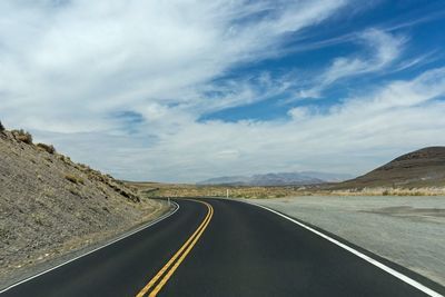 Road passing through mountains against sky