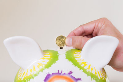 Close-up of hand holding table against white background