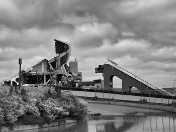 Low angle view of bridge against cloudy sky