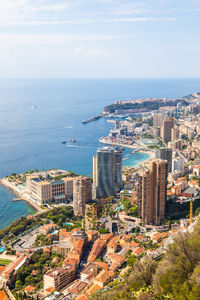 High angle view of cityscape by sea against sky