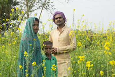 Family of farmer standing on field 
