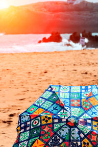 Close-up of multi colored umbrella on beach